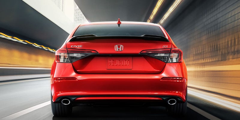 Rear view of a red 2024 Honda Civic Si driving through a tunnel