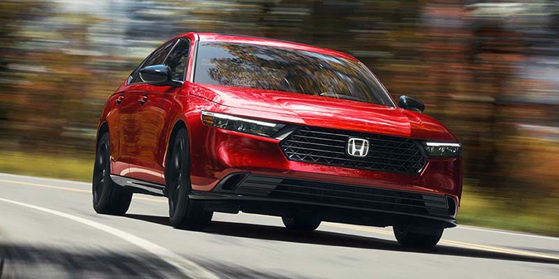 A red 2024 Honda Accord driving down the road