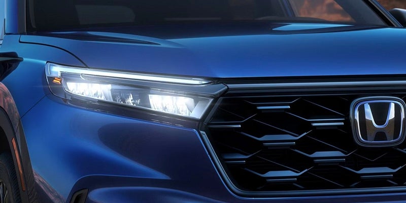 Illuminated headlight on a blue 2024 Honda CR-V
